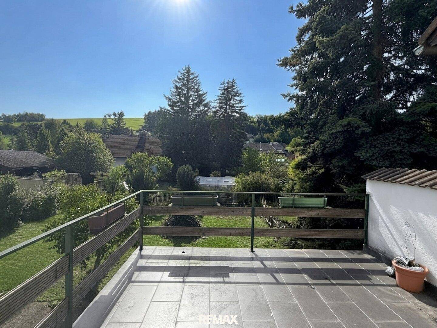 Terrasse mit Fliesenboden und weitem Blick über die grüne Landschaft.