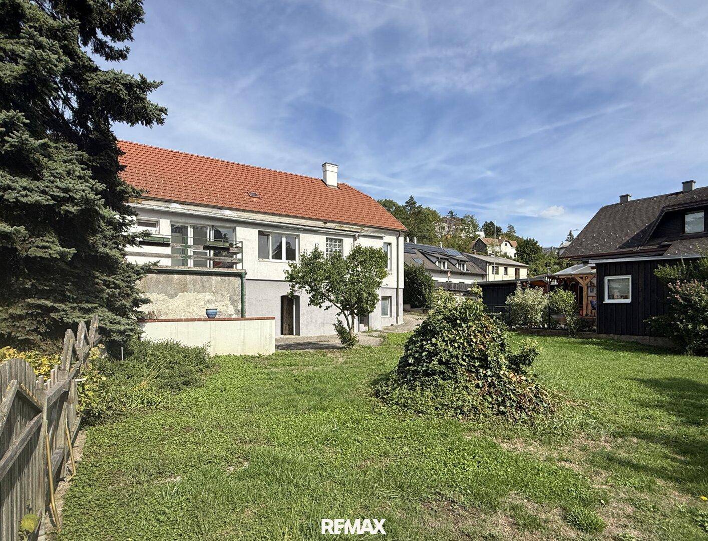 Großer Gartenbereich mit Rasen, Bäumen und Blick auf die Rückseite des Hauses.