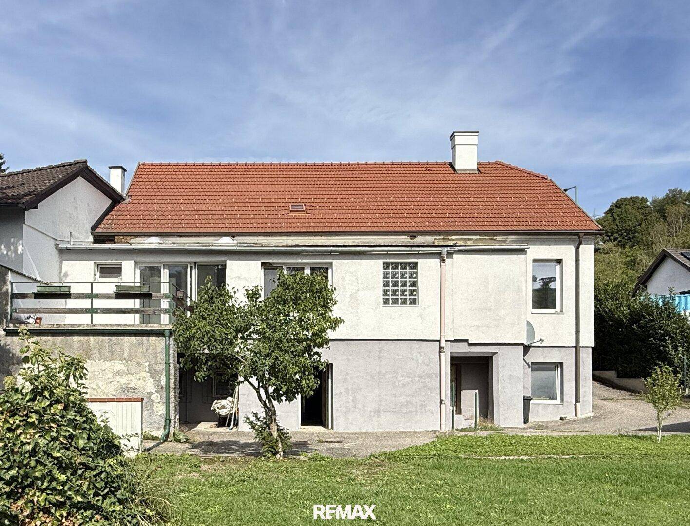 Rückansicht des Hauses mit Garten, Terrasse und Zugang zum Untergeschoss.