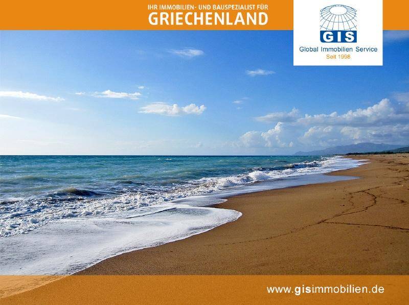 Breiter Sandstrand mit sanften Wellen und klarem Meerwasser unter blauem Himmel.