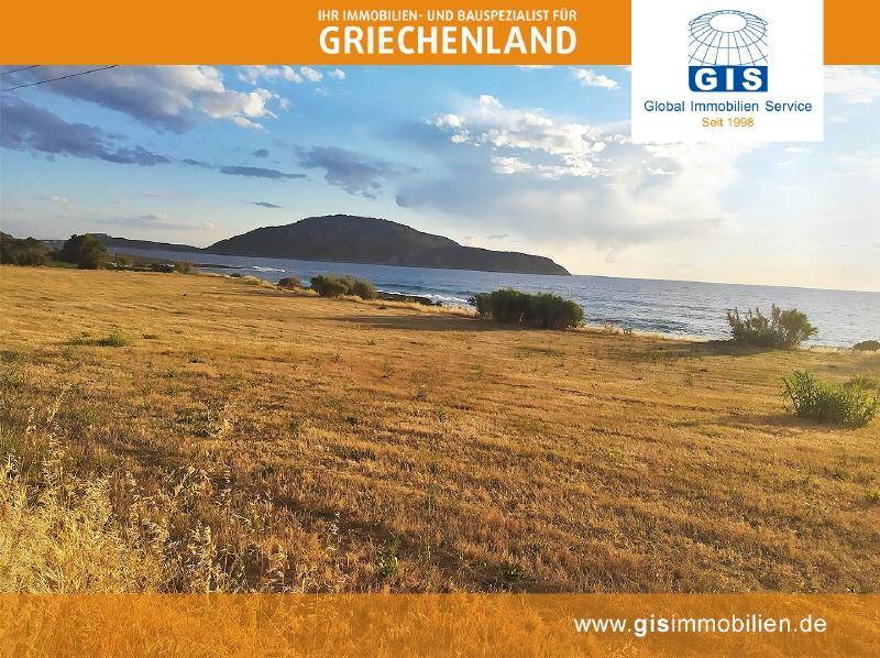 Panoramablick über eine weite, trockene Landschaft mit dem Meer und einem markanten Berg im Hintergrund.