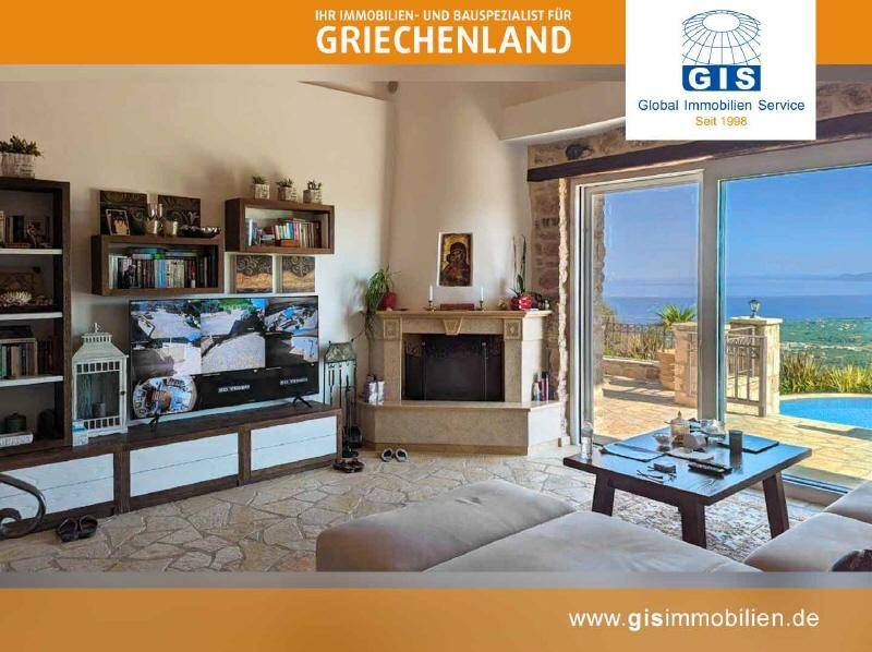 Helles Wohnzimmer mit Kamin, großem Fernseher und direktem Zugang zur Terrasse mit Meerblick.