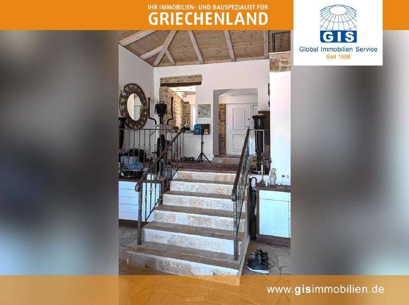 Elegante Steintreppe mit schmiedeeisernem Geländer und rustikalen Holzbalken an der Decke.