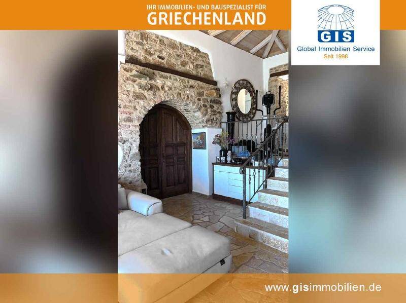 Gemütlicher Wohnbereich mit bequemer Couch, Steinwänden und rustikalen Holzbalken an der Decke.