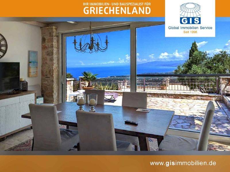 Geräumiger Essbereich mit Holztisch, bequemen Stühlen und weitem Blick auf das glitzernde Meer.