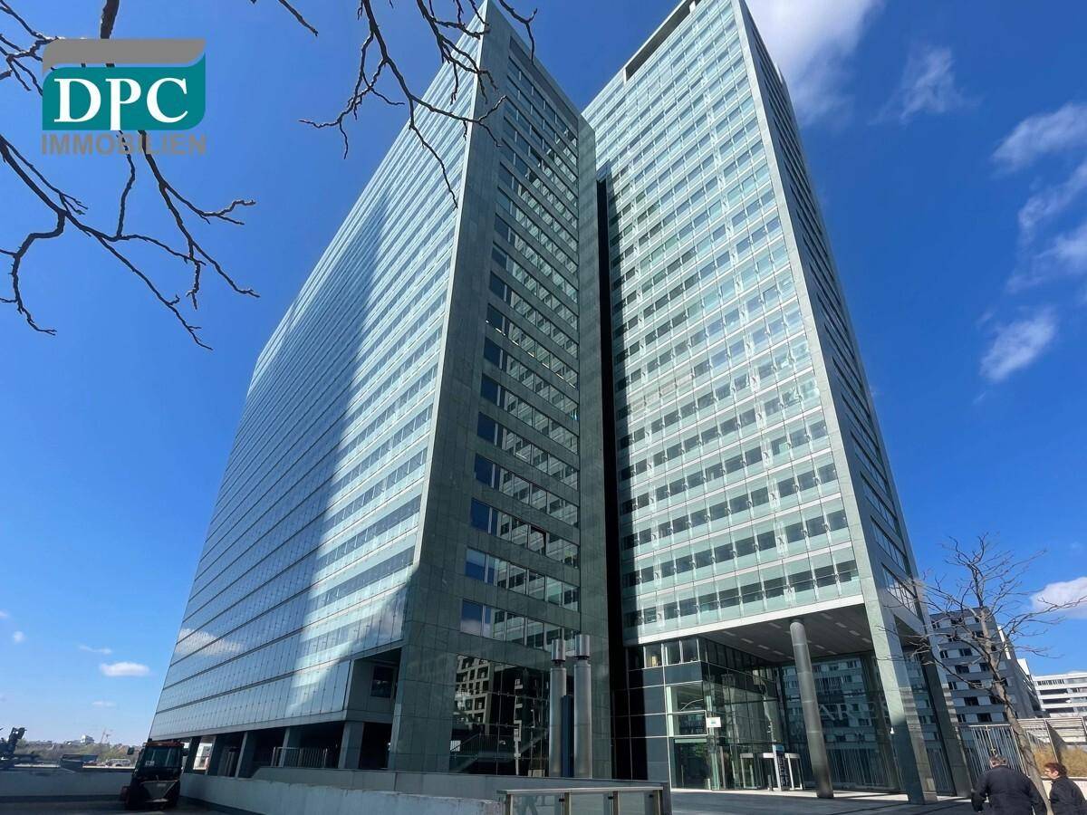 Beeindruckendes Bürogebäude mit spiegelnder Glasfassade und klarem Himmel, das eine moderne Ästhetik aufweist.