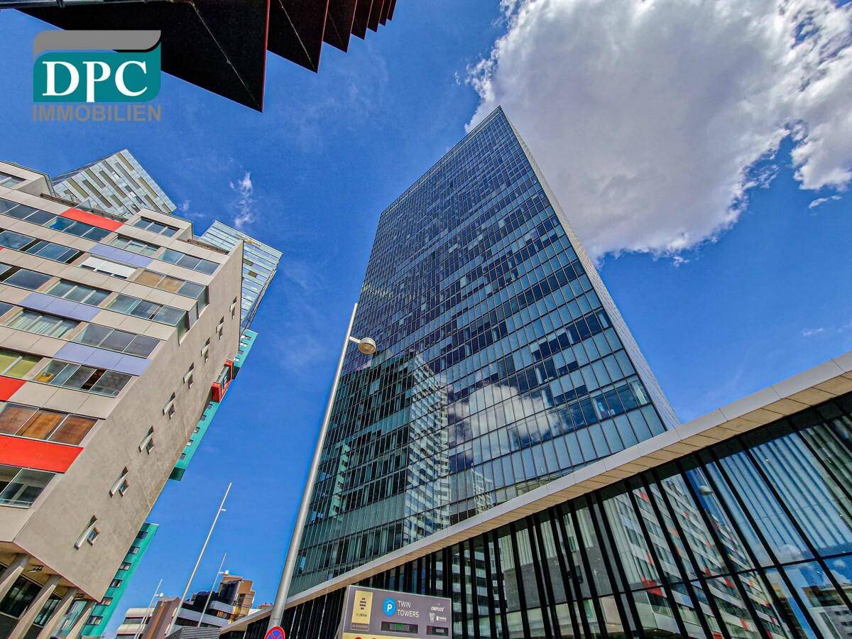 Architektonische Ansicht von modernen Hochhäusern mit markanten Glasfronten und klarem Himmel.