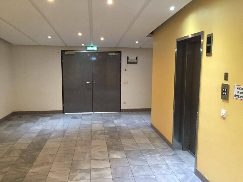 Geräumiger Flur oder Lobby mit Fliesenboden und einem modernen Aufzug.