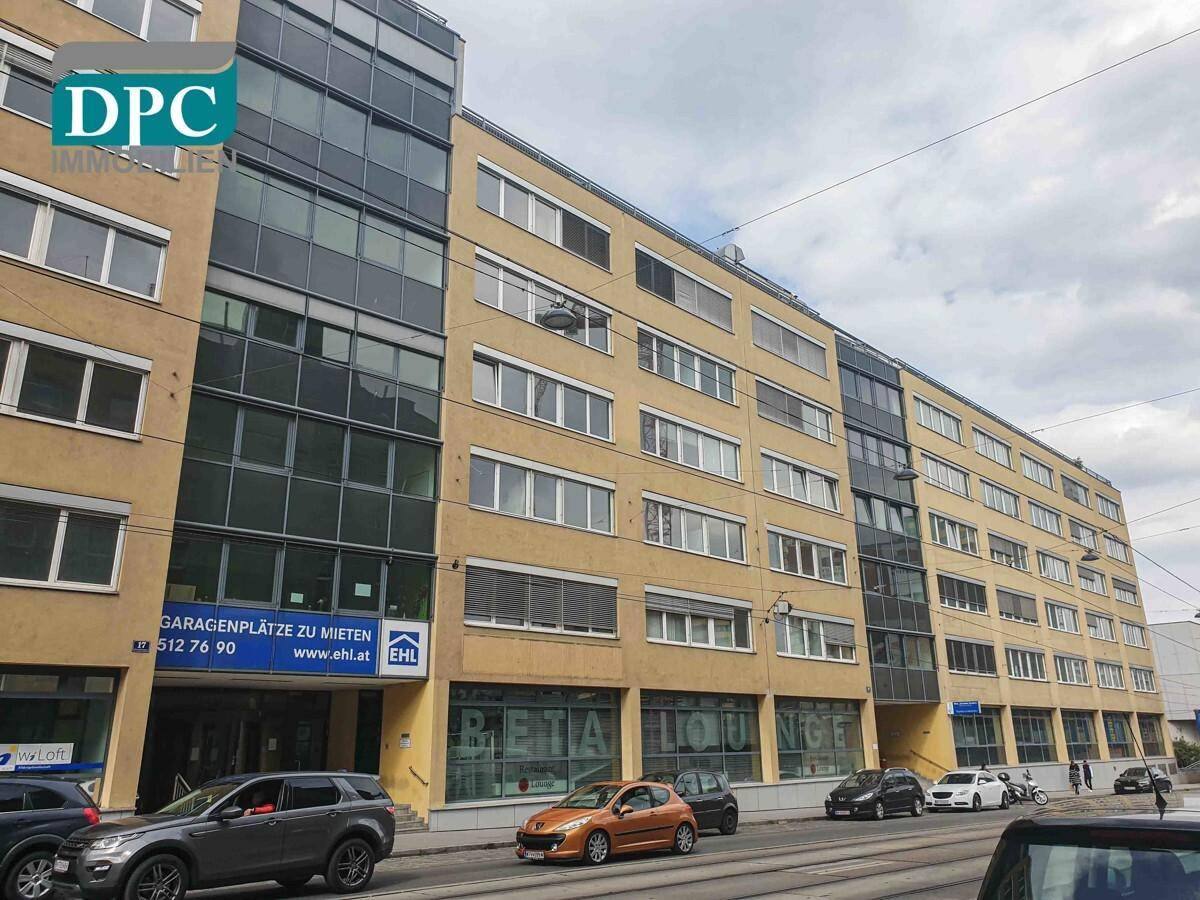 Lange Fassade eines modernen Geschäftsgebäudes mit Mietangeboten für Garagenplätze.