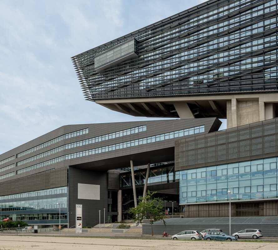 Nahaufnahme der modernen Fassade eines Bürokomplexes mit großen Glasflächen und einzigartiger Bauweise.