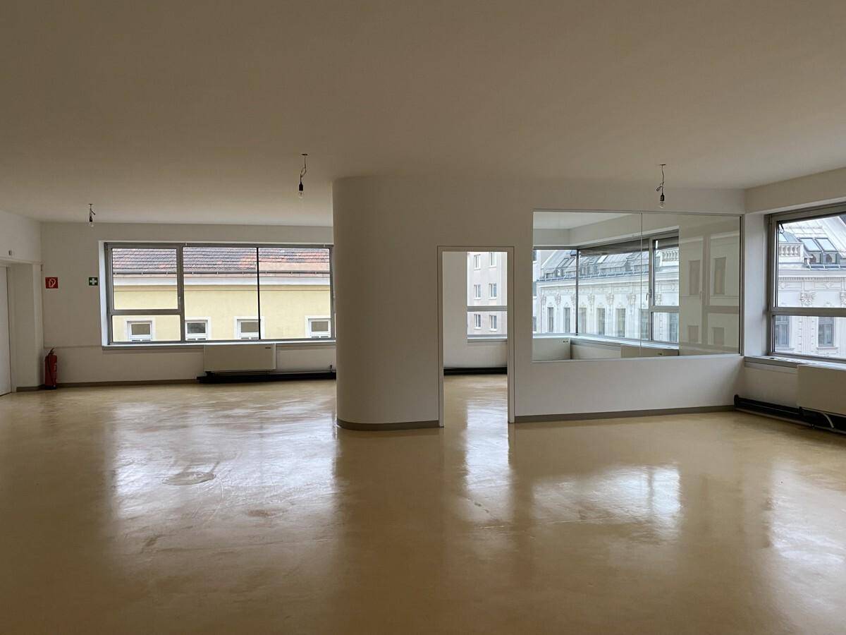 Großer, leerer Büroraum mit vielen Fenstern und glänzendem Boden, bereit zur individuellen Gestaltung.