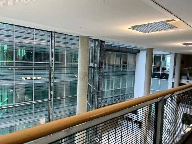 Heller Innenbereich mit hohen Decken und großen Glasfronten, die viel natürliches Licht hereinlassen.