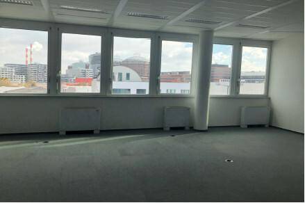 Geräumiger Bürobereich mit einer langen Fensterfront, die einen weiten Blick auf die Stadt bietet.