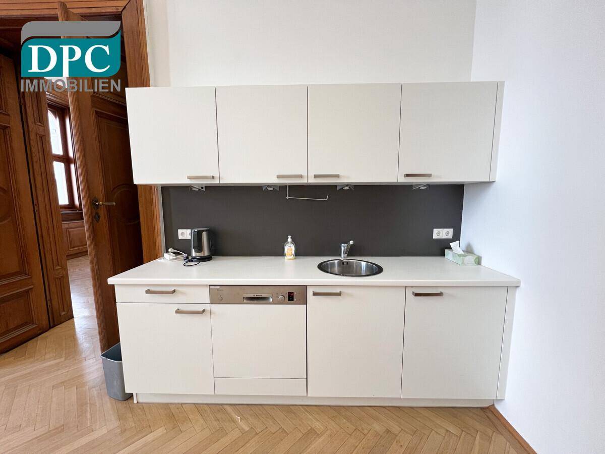 Moderne Küchenzeile mit weißen Schränken, Spüle und integriertem Geschirrspüler.