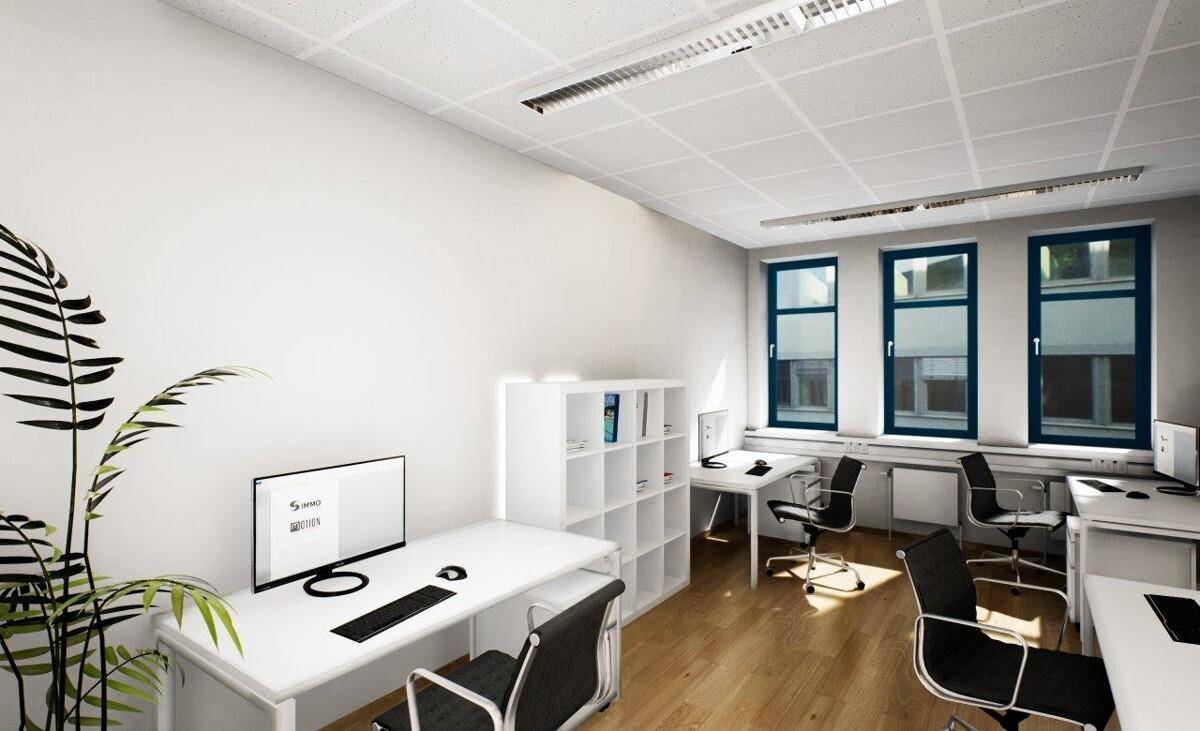 Offener Bürobereich mit mehreren Arbeitsplätzen, Regalen und viel Tageslicht.