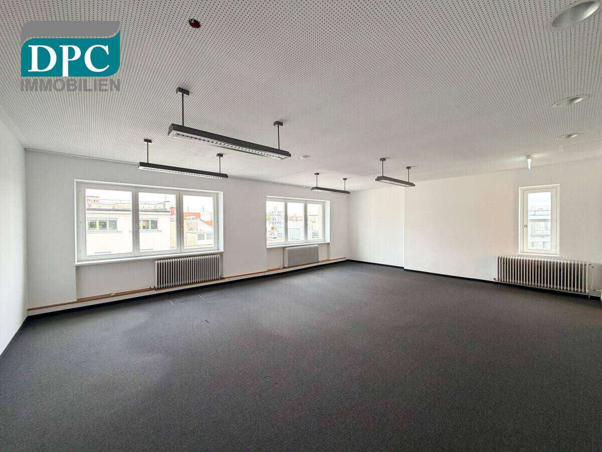 Großes, leeres Büro mit Teppichboden, vielen Fenstern und moderner Beleuchtung, bereit für die individuelle Gestaltung.