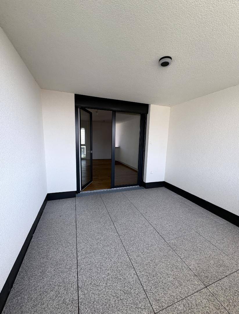 Geräumige Loggia mit Fliesenboden und Zugang zum Innenbereich des Hauses.
