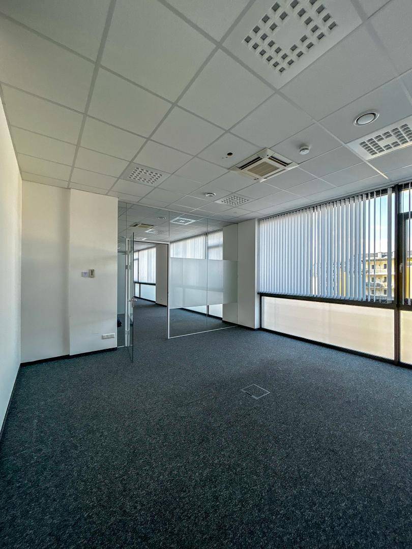 Geräumiges Büro mit Teppichboden, Glaswänden und großen Fenstern, schafft eine offene Arbeitsatmosphäre.
