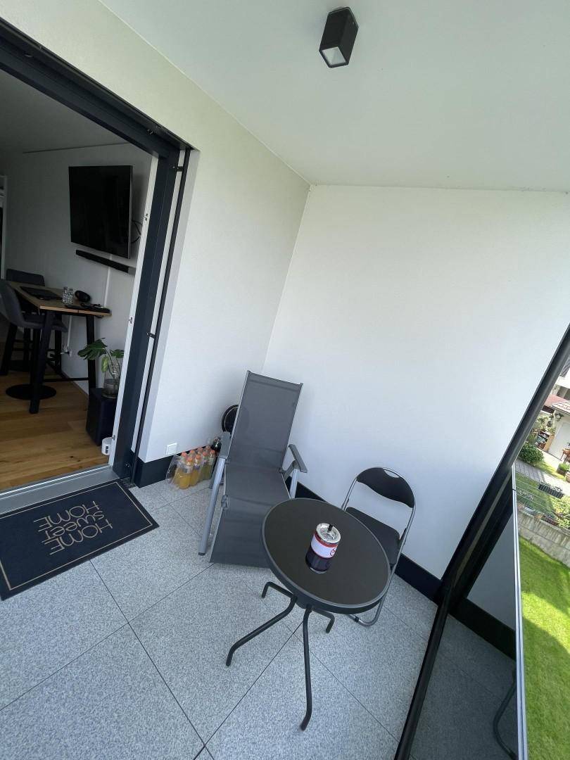 Terrasse mit Glasgeländer und direktem Zugang zum Wohnbereich, ideal für entspannte Stunden.