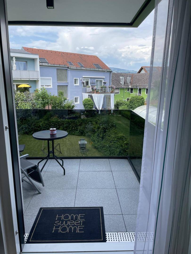 Gemütliche Terrasse mit Sitzgelegenheiten und Blick auf den Garten und die Nachbarschaft.