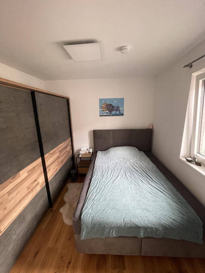 Helles Schlafzimmer mit Doppelbett und modernem Kleiderschrank.