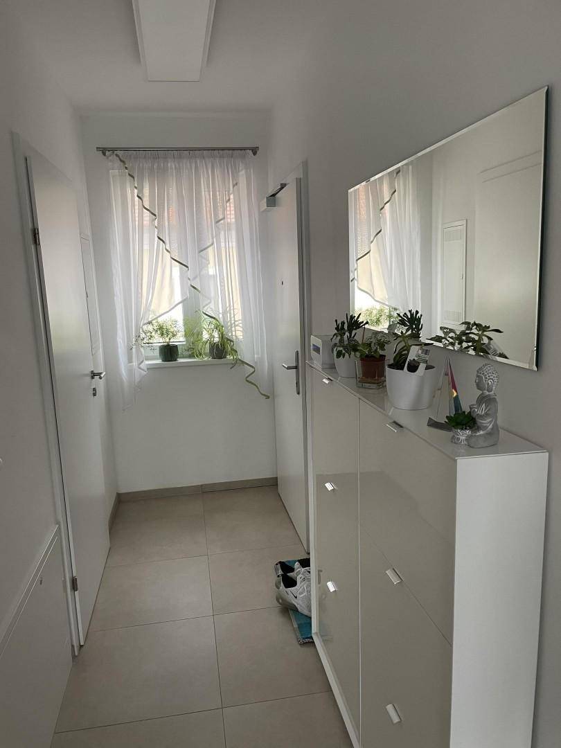 Eingangsbereich des Flurs mit Fenster, Schuhschrank und großem Spiegel.