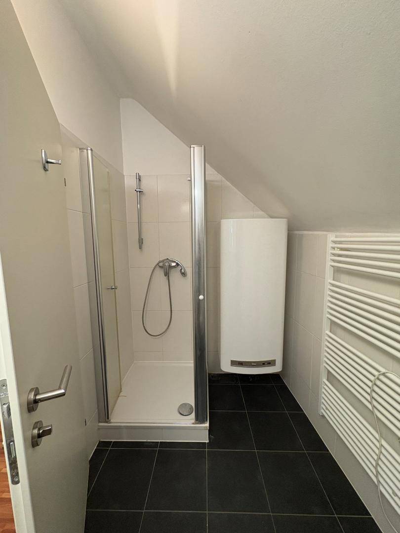 Badezimmer im Dachgeschoss mit Dusche, Boiler und beheiztem Handtuchhalter.