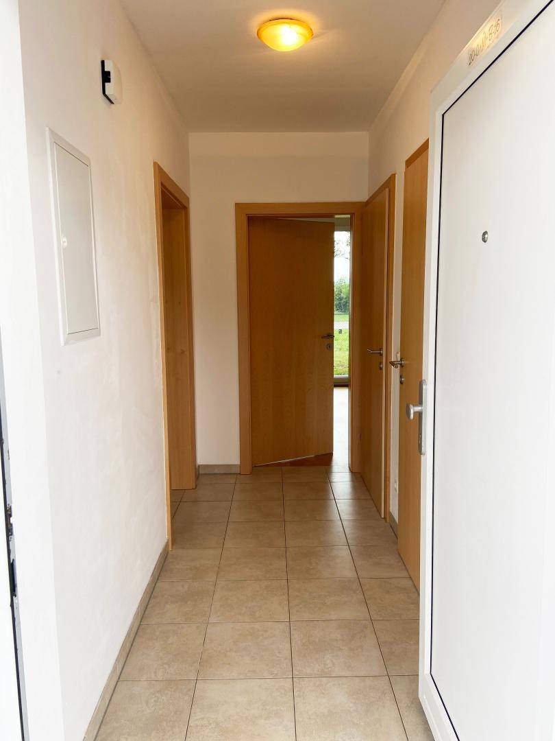 Geräumiger Flur mit Fliesenboden und Zugang zu verschiedenen Zimmern der Wohnung.