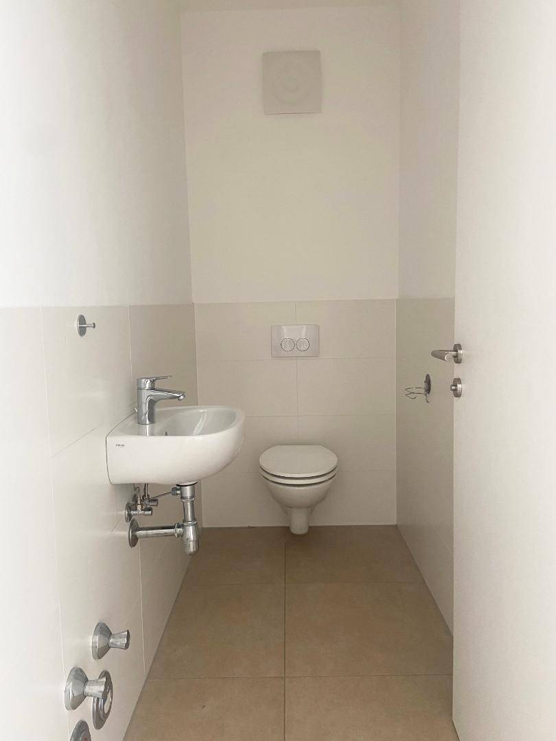 Separates Gäste-WC mit Waschbecken und wandhängender Toilette.