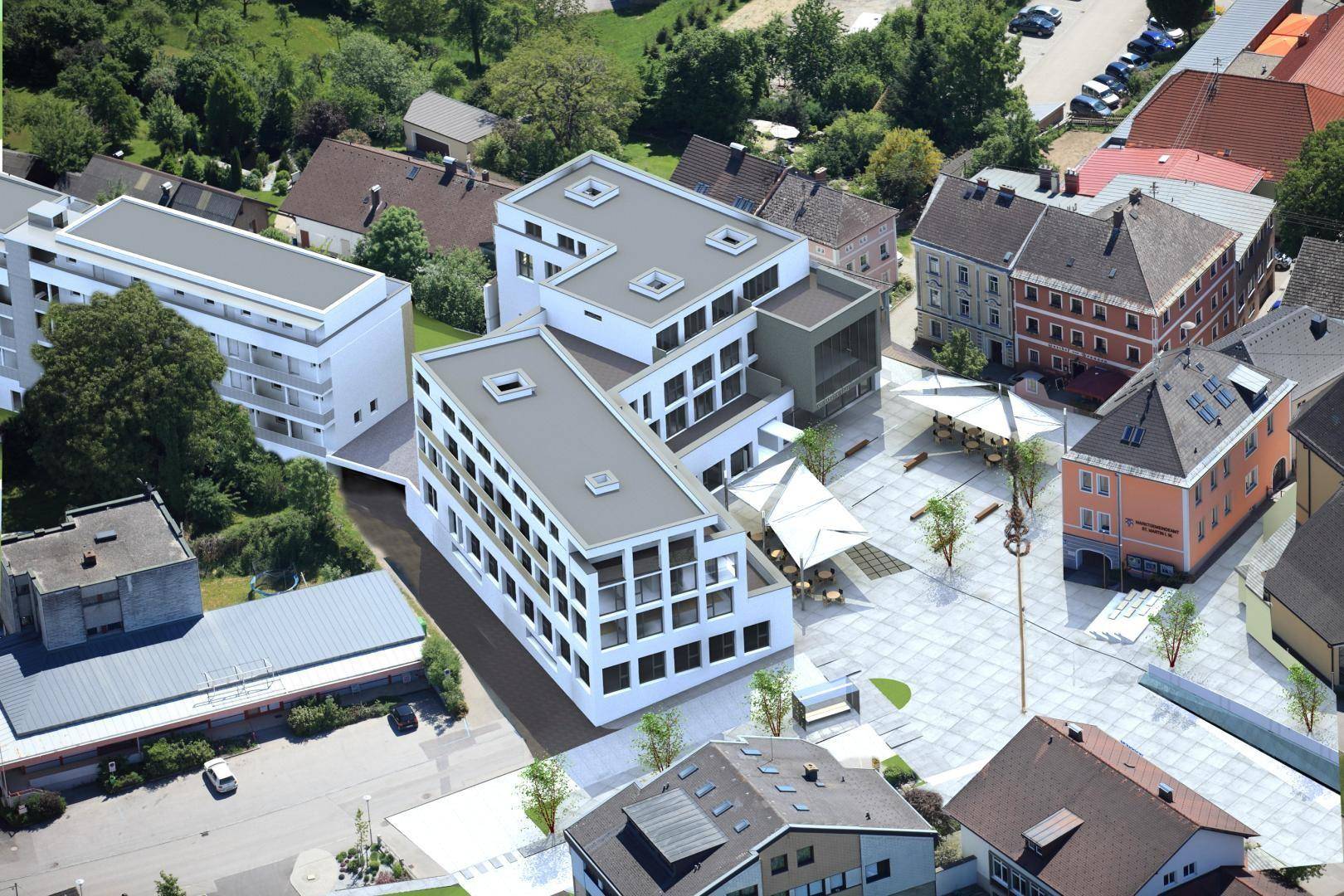 Luftaufnahme eines modernen Gebäudekomplexes in städtischer Umgebung mit umliegenden Häusern.