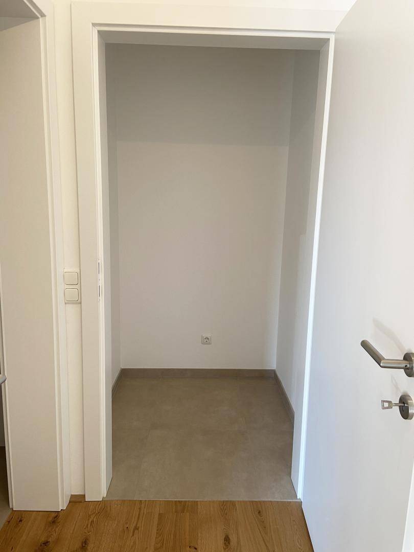 Kleiner Abstellraum mit Fliesenboden und weißen Wänden, ideal für zusätzlichen Stauraum.