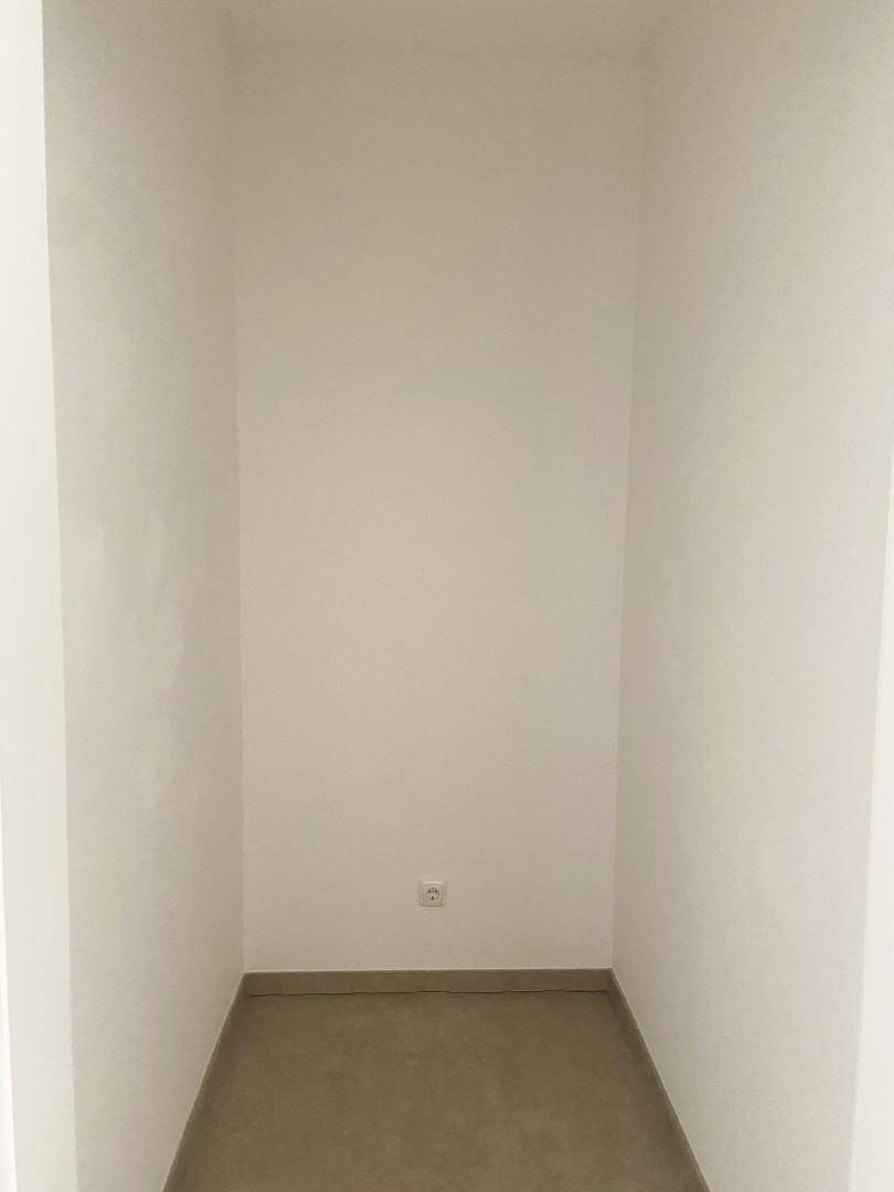 Kleiner, leerer Abstellraum mit weißen Wänden und praktischem Fliesenboden.