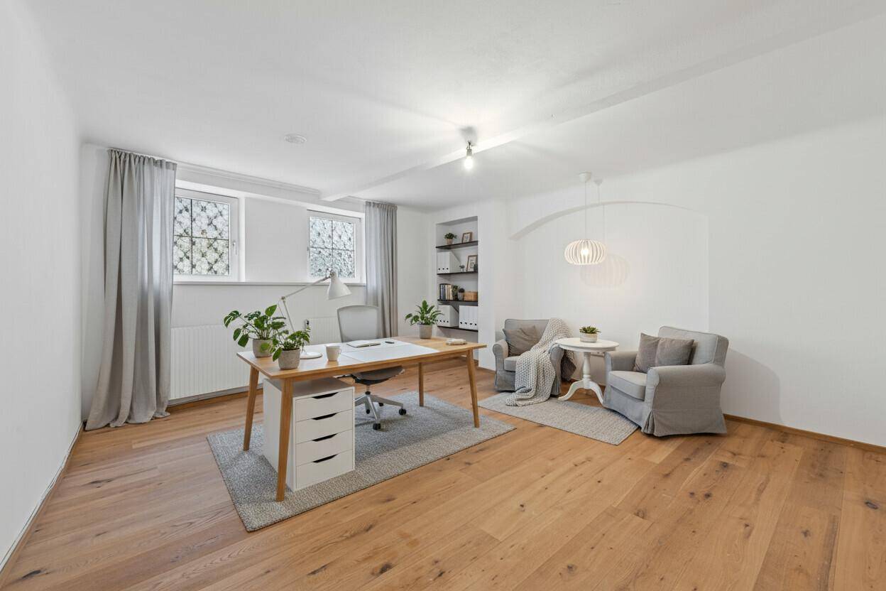Geräumiges Arbeitszimmer mit Holzboden, großen Fenstern und moderner Einrichtung.