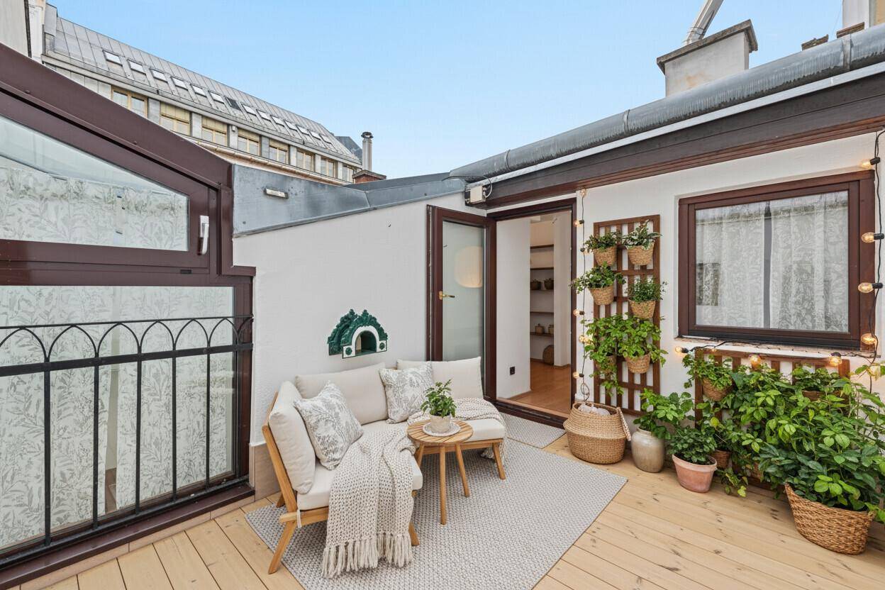 Charmante Dachterrasse mit Holzboden, gemütlicher Sitzgelegenheit und Pflanzen.