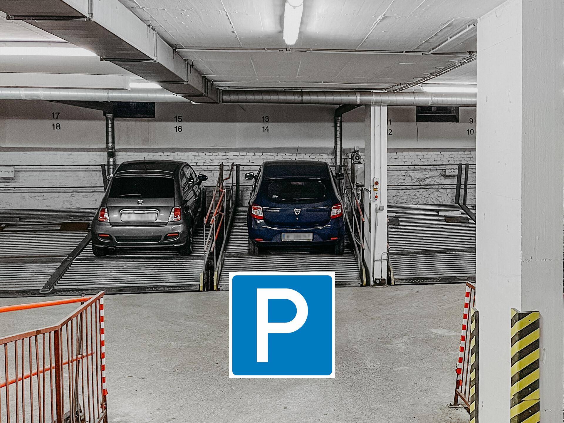 Tiefgarage mit zwei parkenden Autos und nummerierten Stellplätzen.