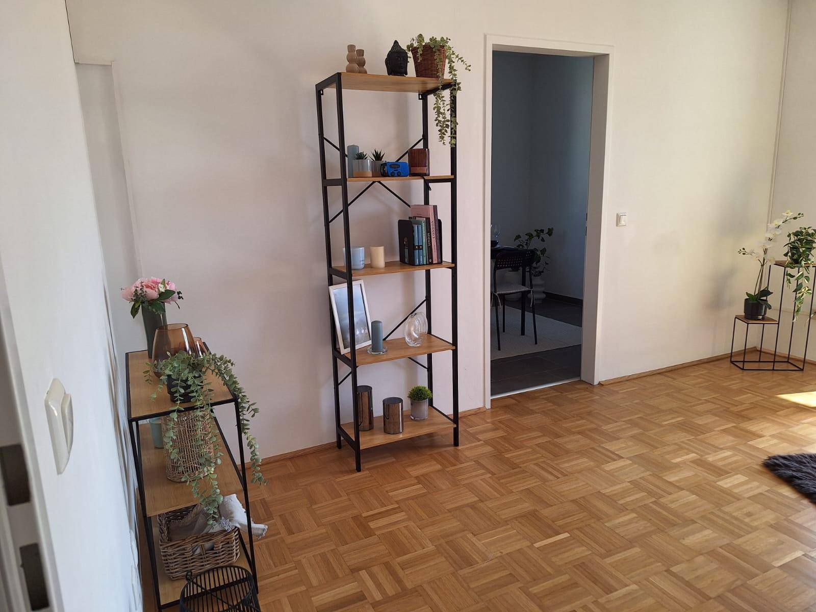 Heller Raum mit Parkettboden und modernen Regalen, ideal als Wohn- oder Arbeitsbereich.