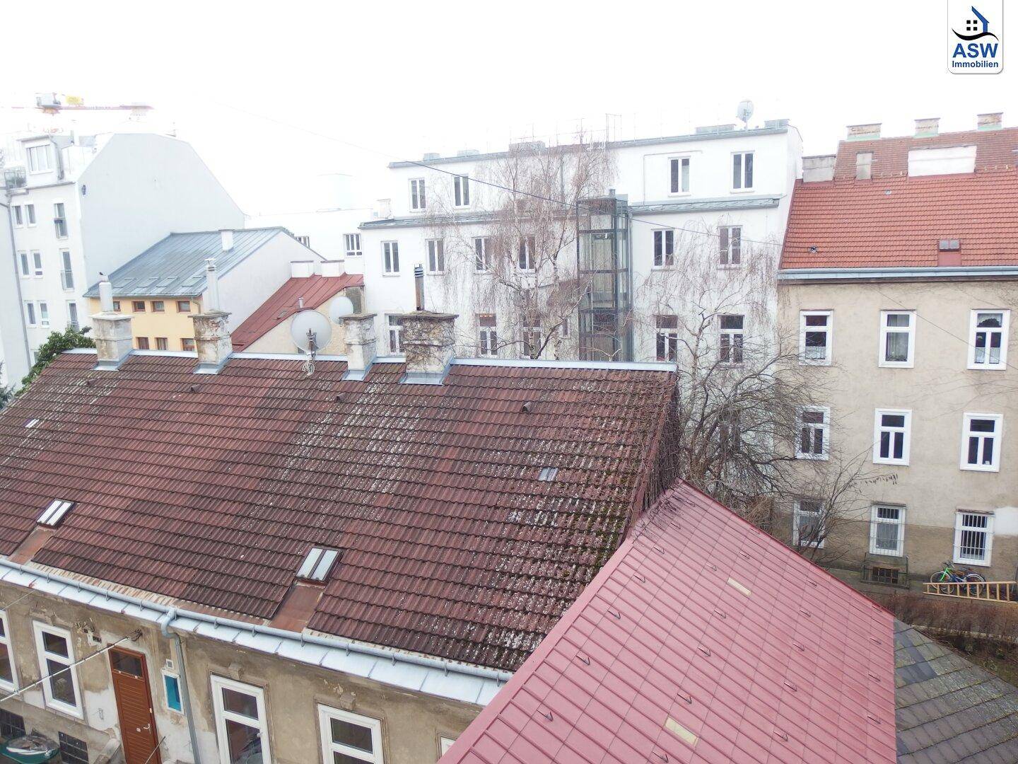 Weitblick über die Dächer der Stadt mit verschiedenen Gebäuden und einem Aufzug im Hintergrund.