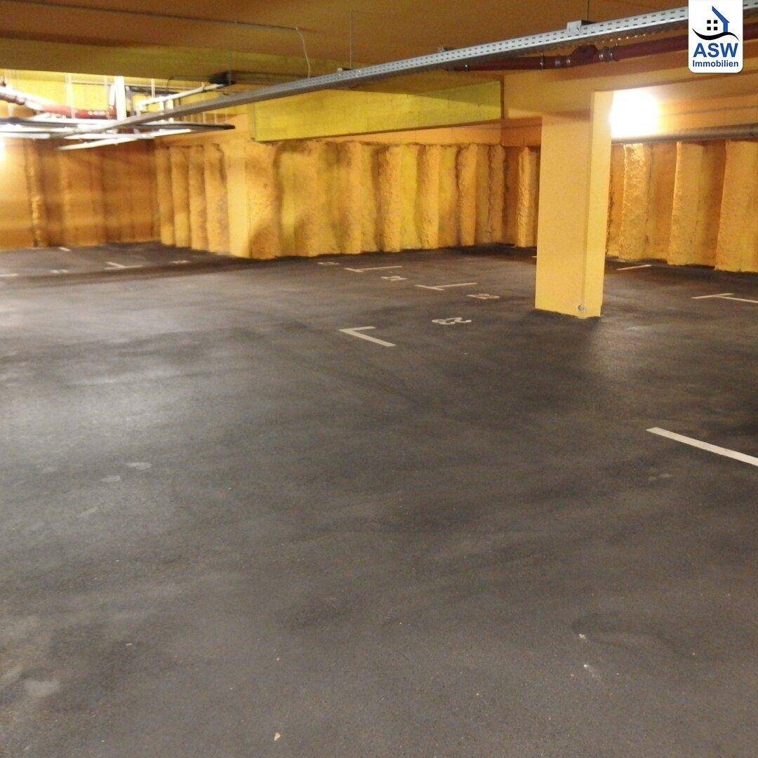 Ansicht einer Tiefgarage mit gelben, isolierten Wänden und einem robusten Betonboden für Fahrzeuge.