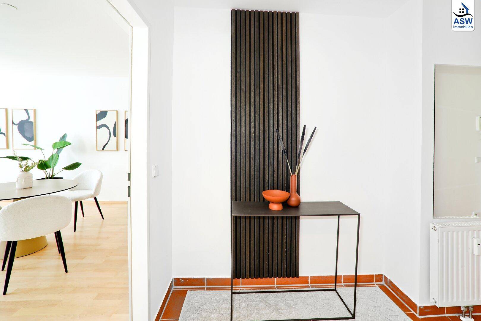 Moderner Flur mit dunkler Holzvertäfelung und stilvoller Dekoration, die zum Wohnbereich führt.