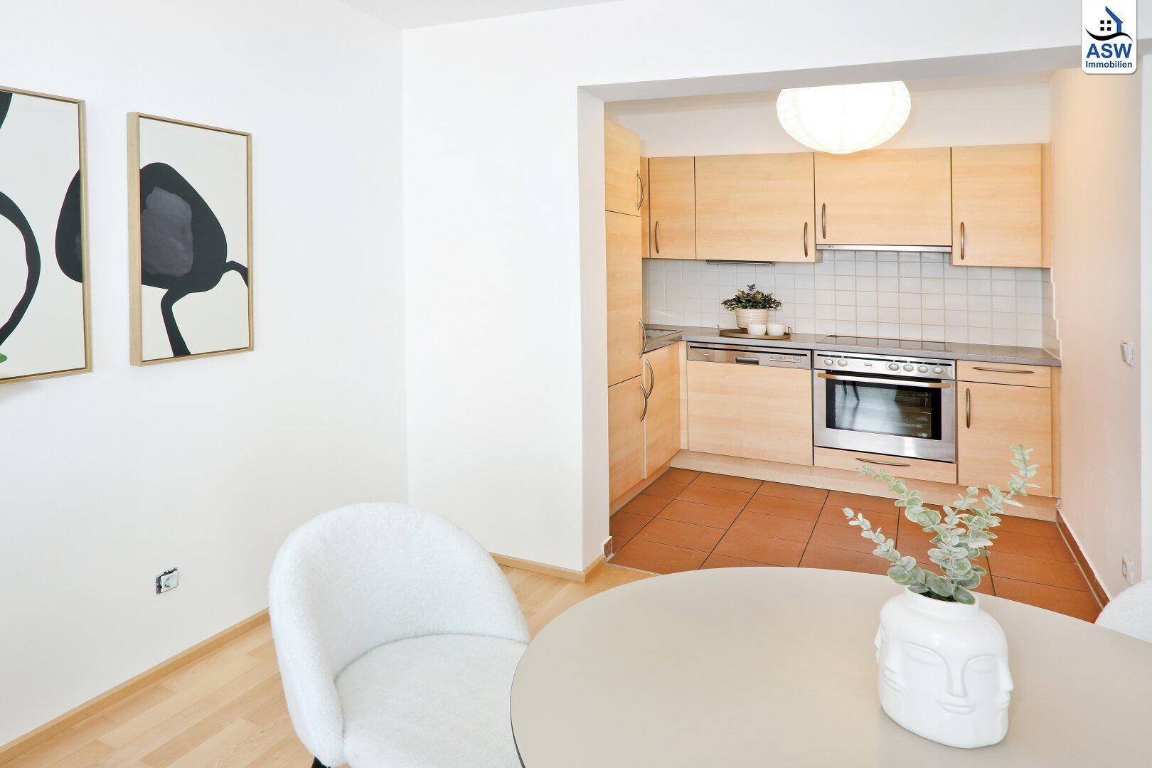 Essbereich mit modernem Tisch und Stühlen, angrenzend an die helle Küche.