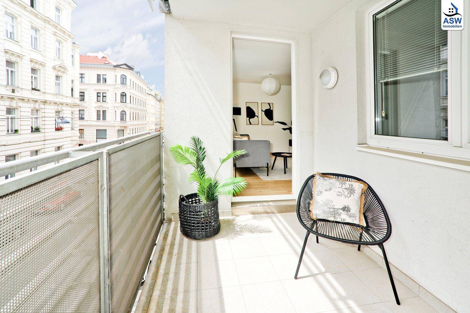 Heller Balkon mit Blick auf die umliegenden Gebäude und direktem Zugang zum Wohnbereich.
