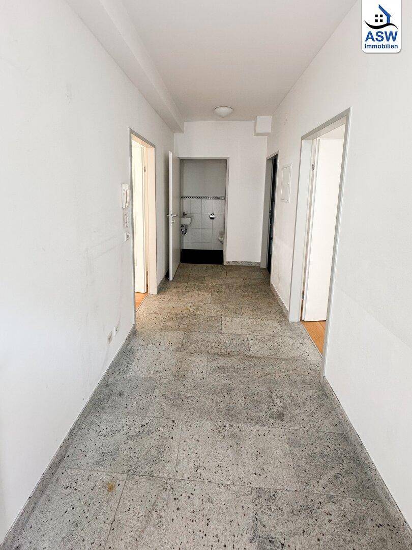 Langer Flur mit Fliesenboden und Zugang zu verschiedenen Räumen, verbindet die Wohnbereiche.