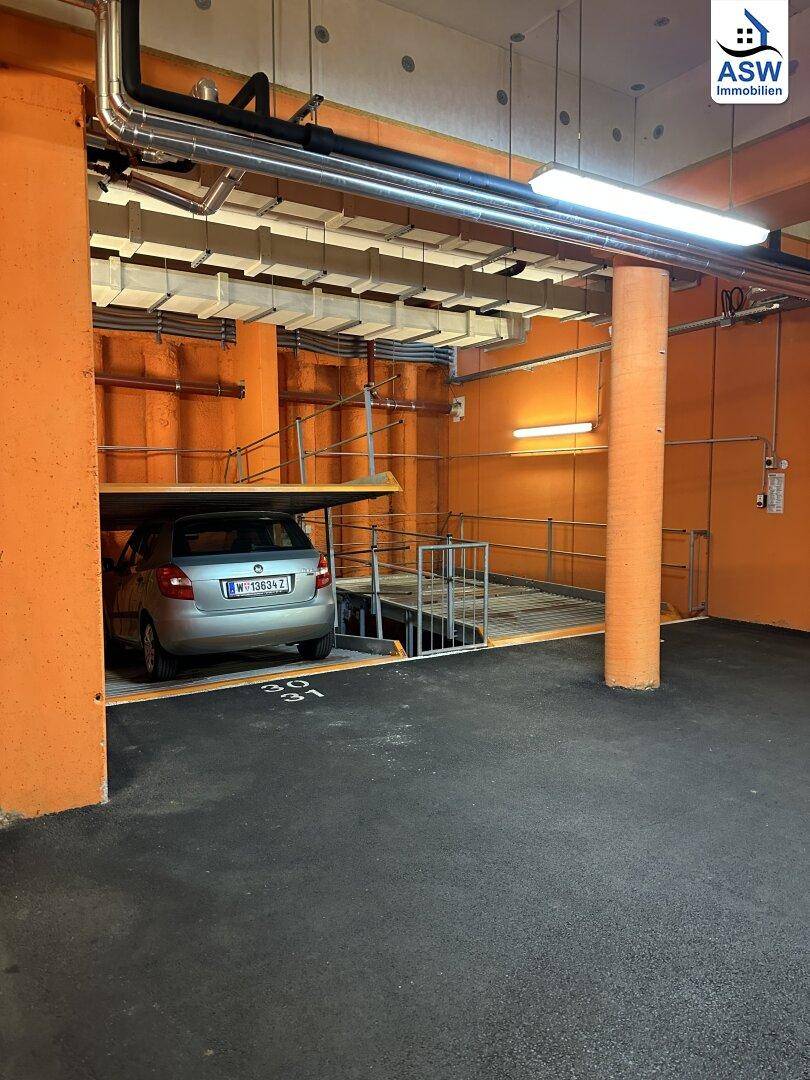 Tiefgarage mit Doppelparker-System und hellen Säulen, bietet effiziente Parkmöglichkeiten.