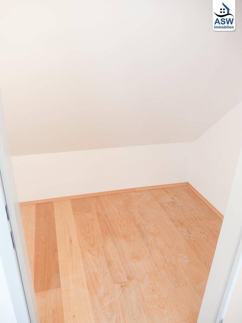 Kleiner Abstellraum im Dachgeschoss mit Holzboden und schrägen Wänden.