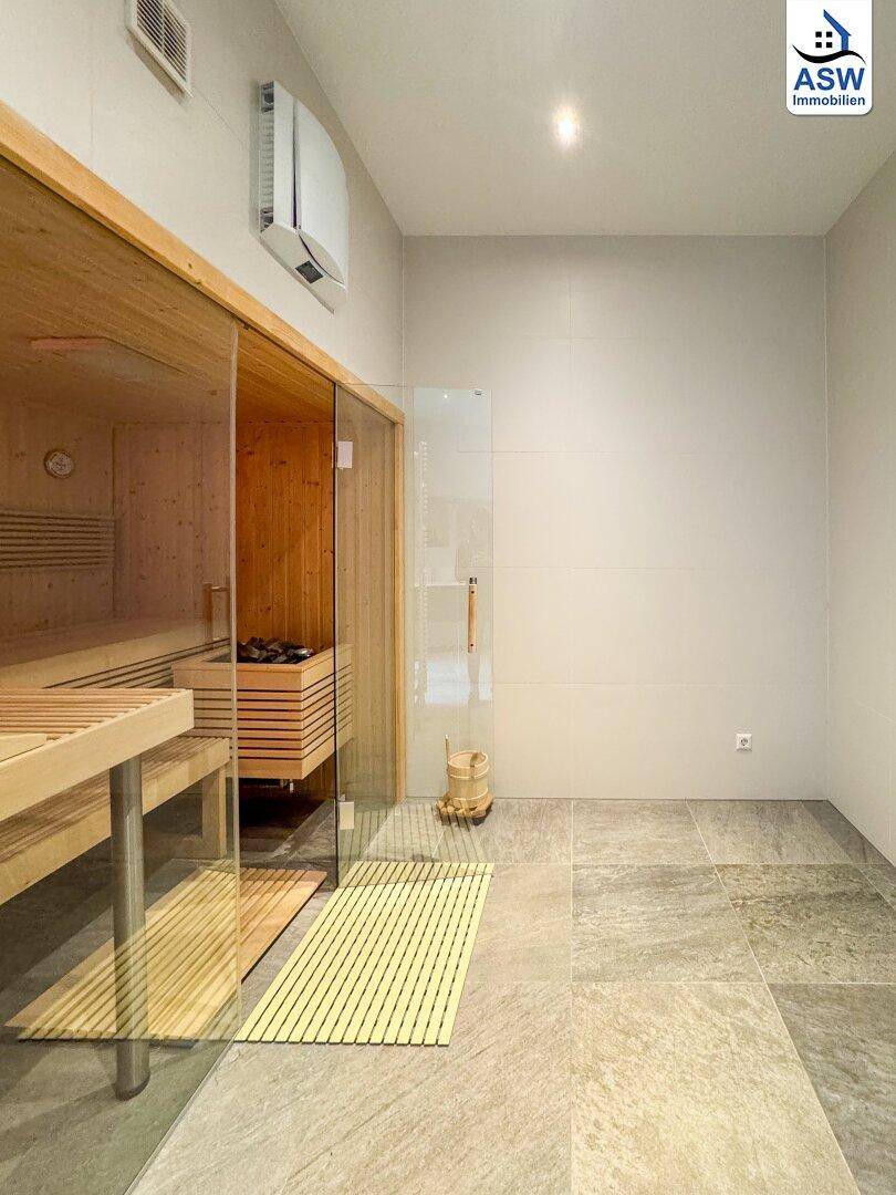 Private Sauna mit Holzbänken und Heizofen, ideal zur Entspannung und Erholung.