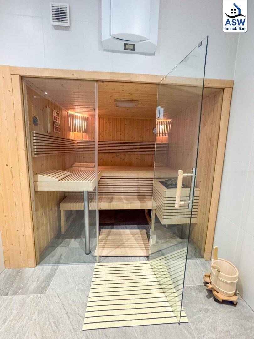 Moderne Sauna mit Glasfront und Holzinterieur, bietet einen luxuriösen Rückzugsort.