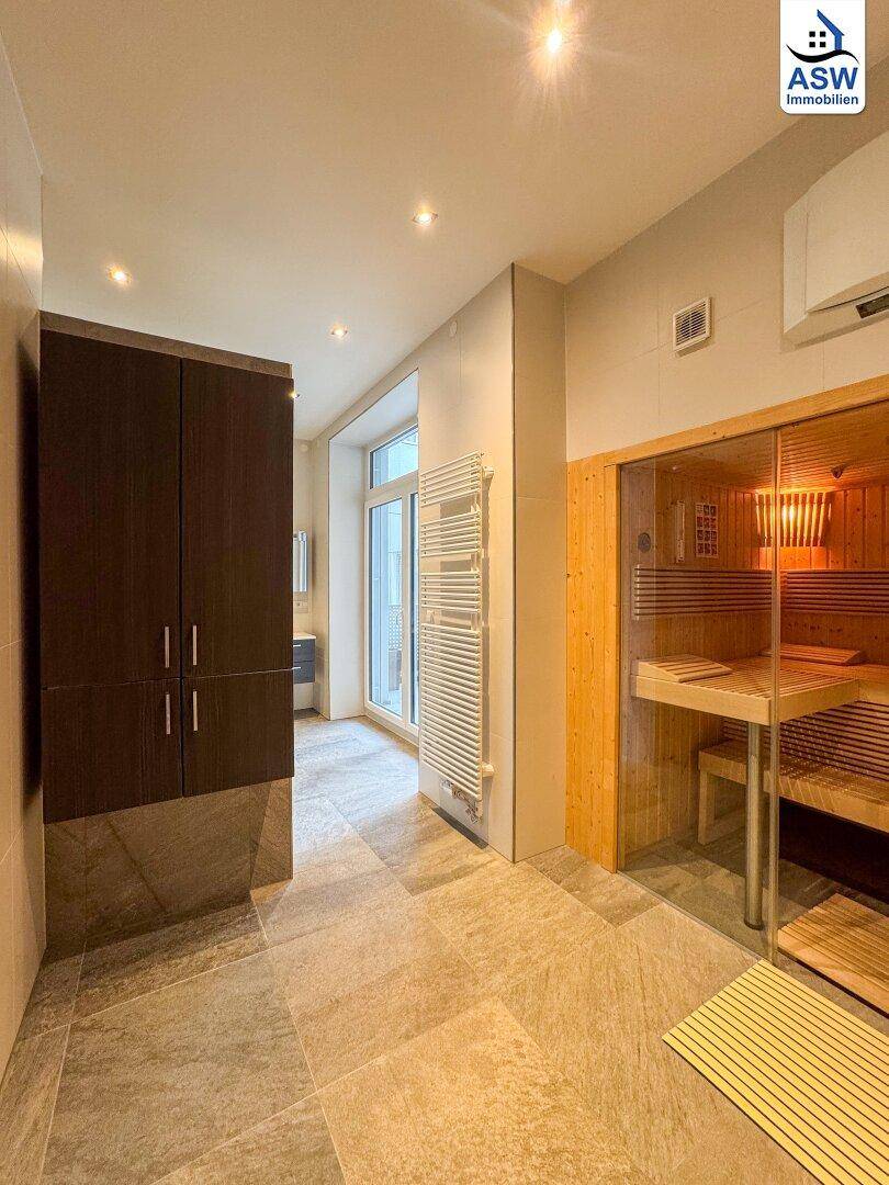 Modernes Badezimmer mit integrierter Sauna, Fliesenboden und Handtuchheizkörper für Wellness.