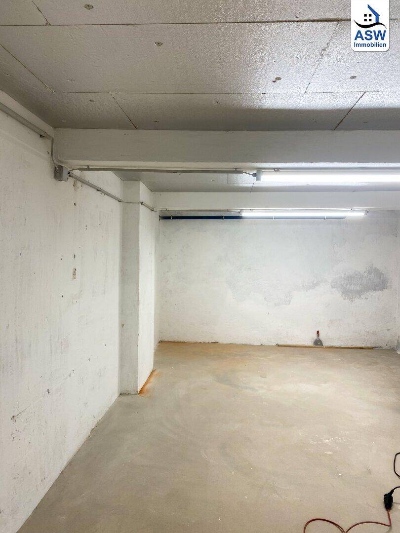 Geräumiger, unfertiger Kellerraum mit Betonboden und sichtbaren Leitungen, bereit für Ausbau.