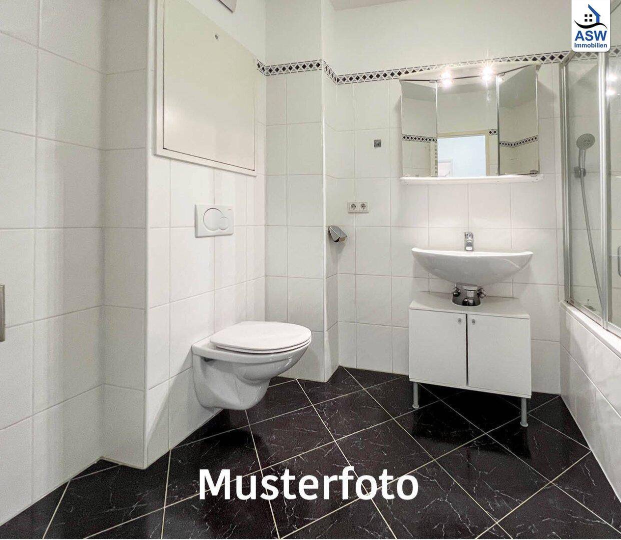 Badezimmer mit weißen Fliesen, dunklem Boden und einer Duschkabine.