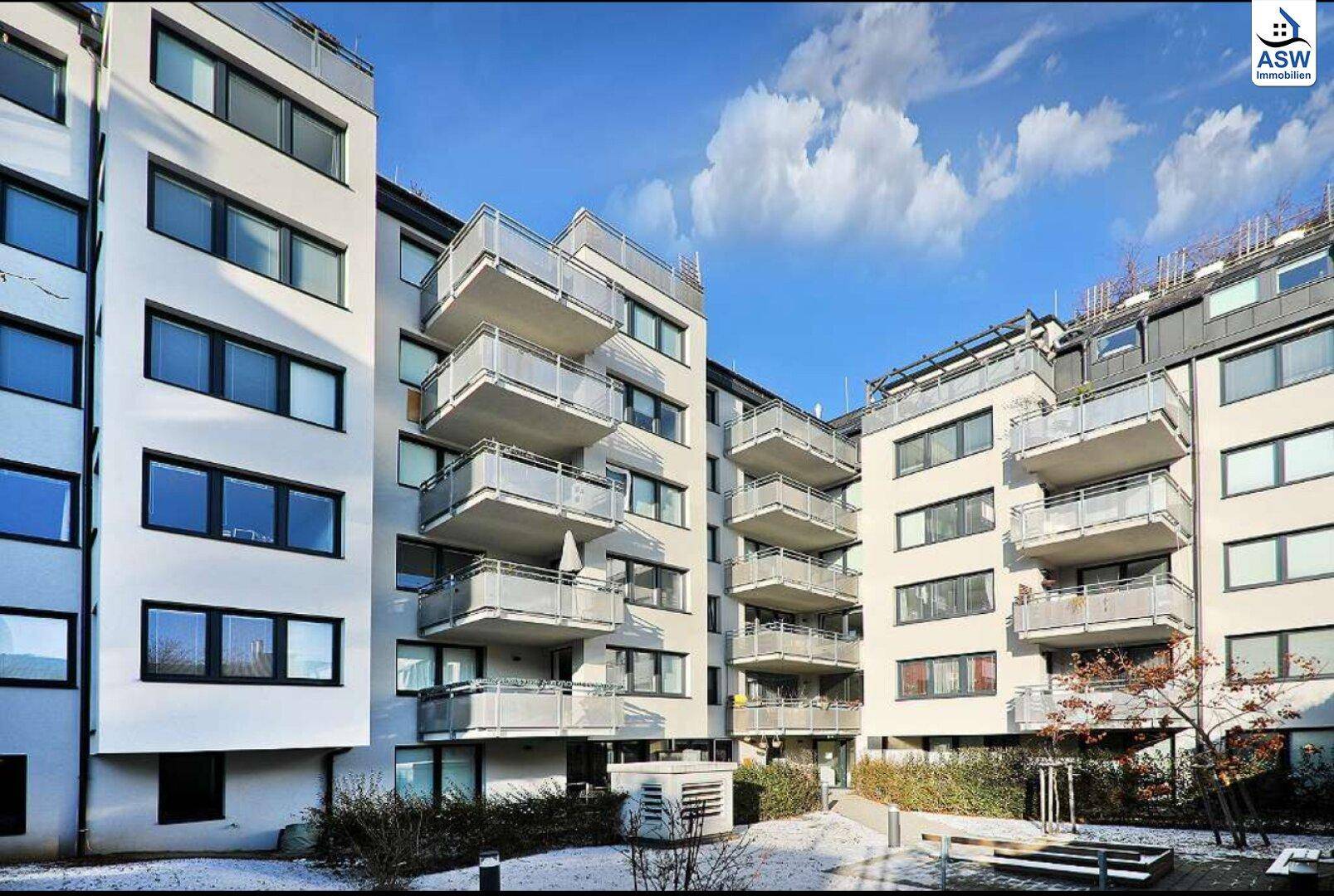 Moderne Wohnanlage mit mehreren Balkonen und einem gepflegten Innenhof.